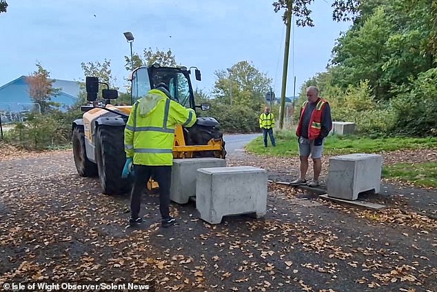 Frustrated locals use forklift trucks to clear concrete barriers that shut off their homes for months beside the historic Parkhurst Prison on the Isle of Wight